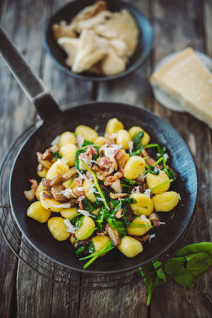 Gnocchi with spinach and mushrooms in a pan