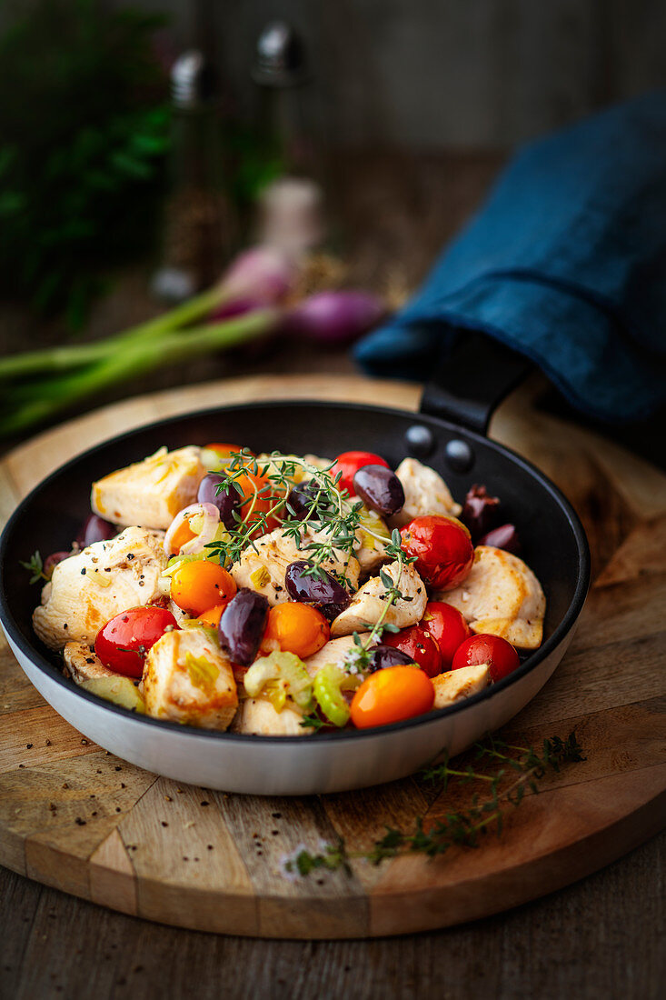 Sauteed Chicken with tomatoes and olives in a pan