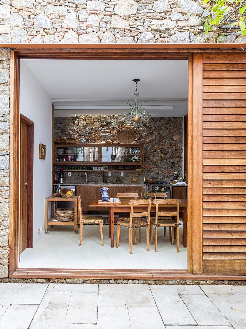 View from terrace through sliding door into rustic dining room