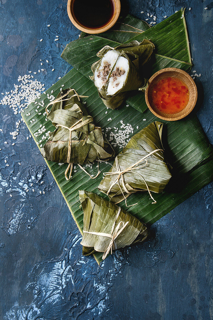 Asian rice piramidal steamed dumplings from rice tapioca flour with meat filling in banana leaves