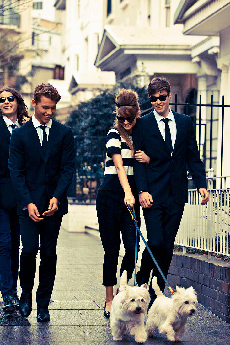 Elegantly dressed young people with dogs