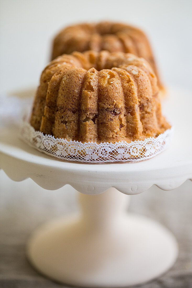 Zwei Mini Kaffeekuchen mit Mandeln auf Kuchenständer