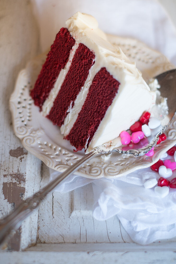 Ein Stück Red Velvet Cake und Herzbonbons