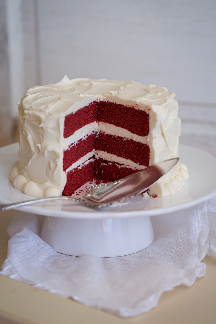 Red Velvet Cake auf Tortenständer, angeschnitten