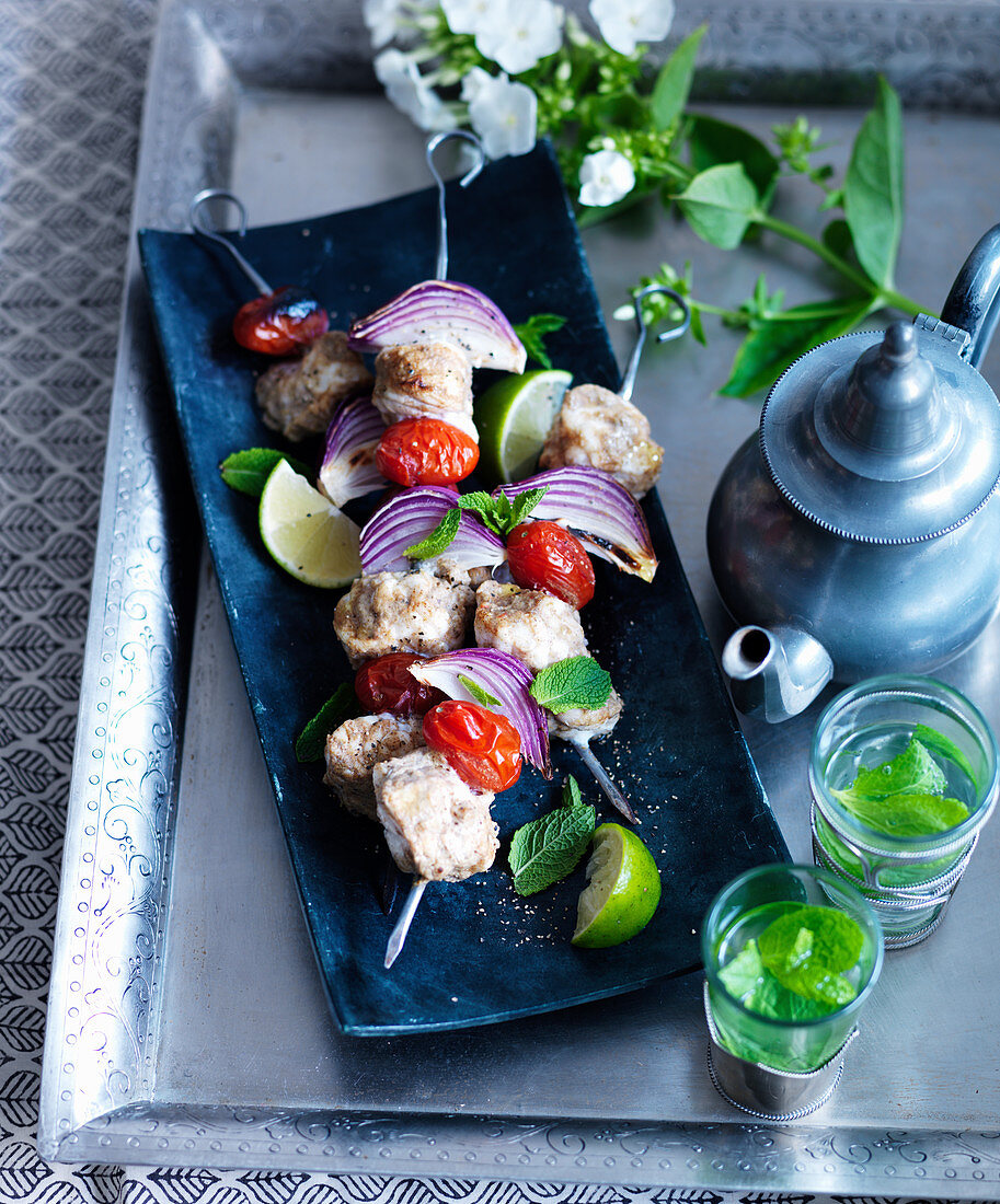 Fish skewers with red onions and limes, with peppermint tea