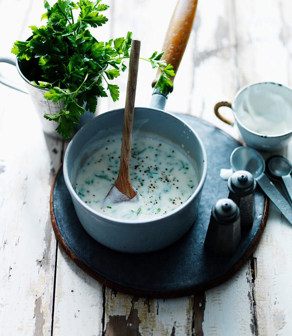 Parsley sauce with salt and pepper in a saucepan