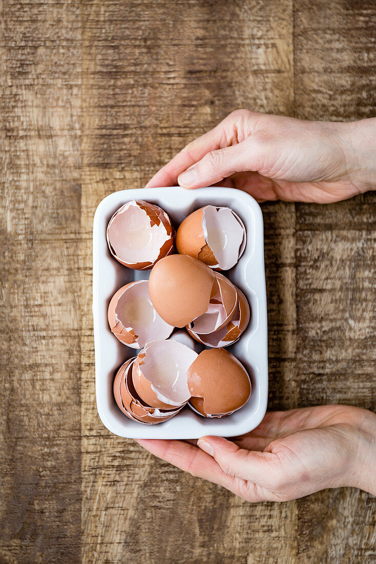 A woman holding broken egg shells