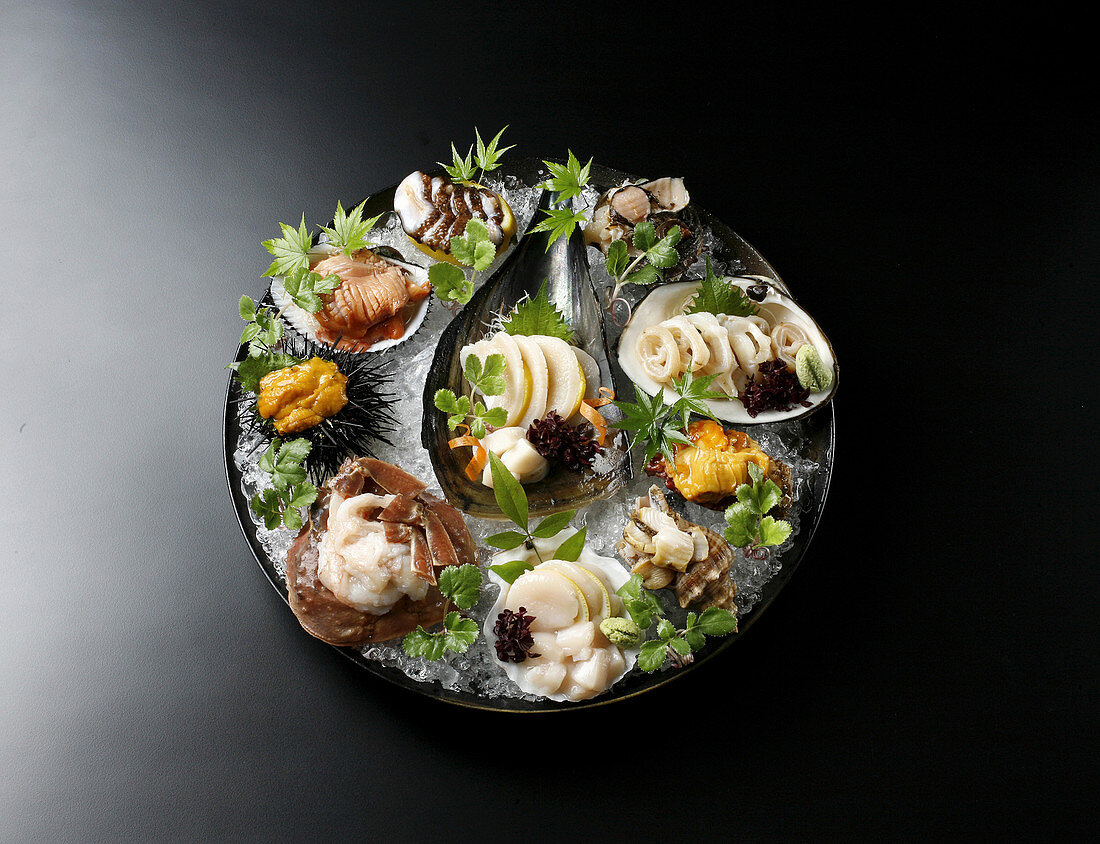 Verschiedene Sashimi serviert in Muschelschalen auf Eis (Japan)