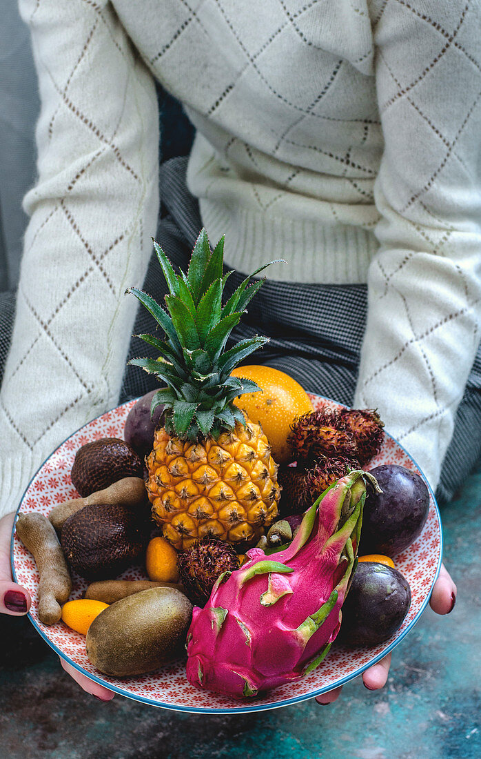 Exotic fruits on a plate in hands