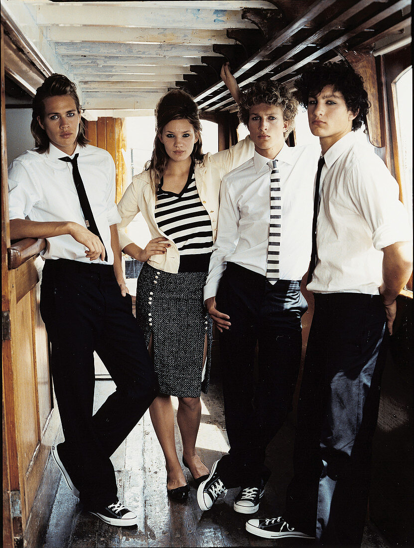 Vier junge Leute in schwarz-weißen Outfits an der Theke