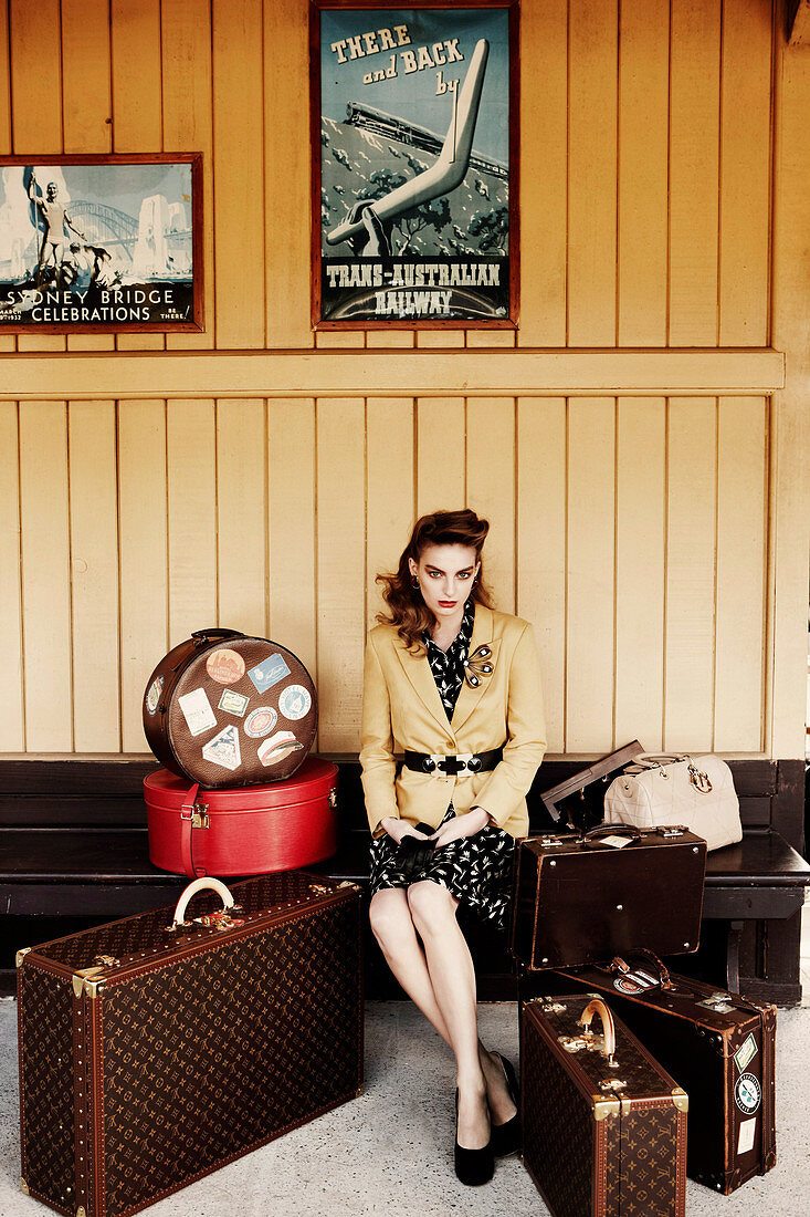 Junge Frau mit Koffern am Bahnhof im Wartesaal