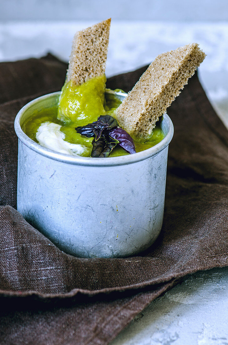 Erbsensuppe mit Brotstreifen und Basilikum