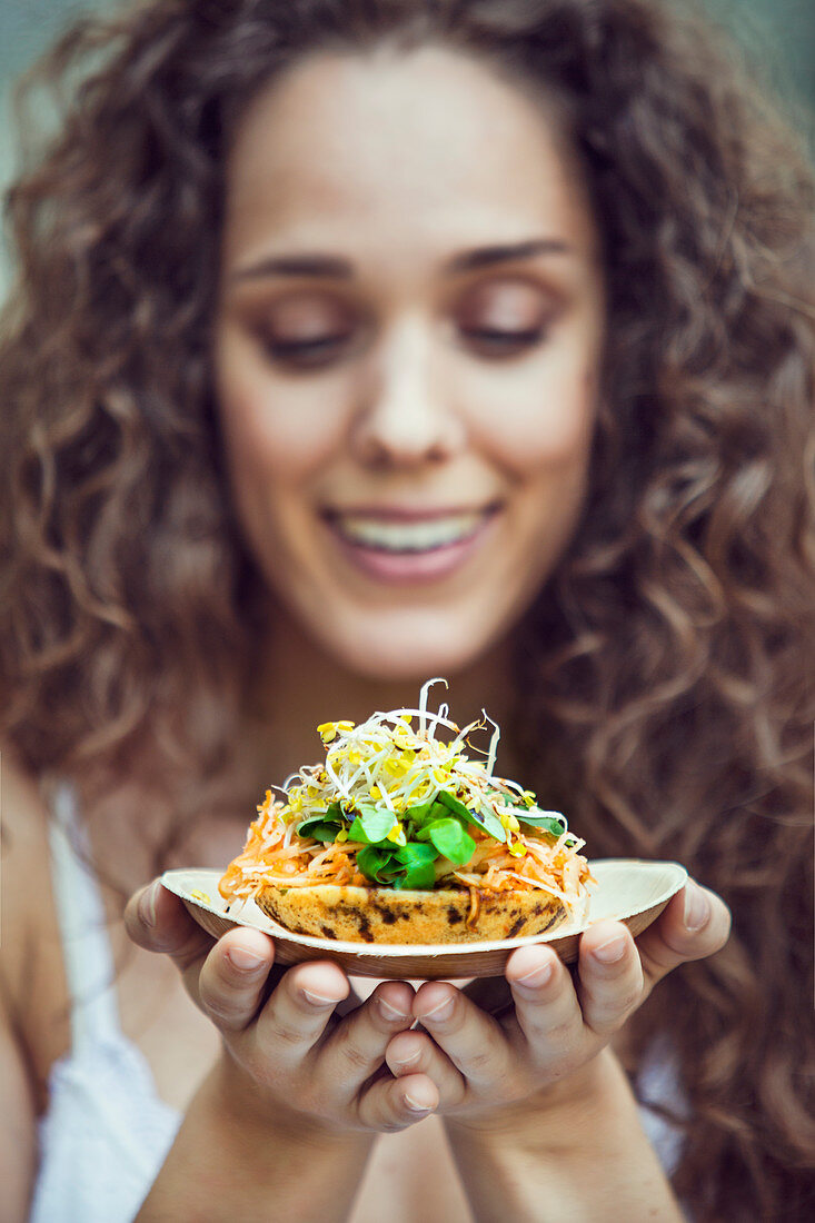 A young woman with surabi (spicy pancake, Indonesia)