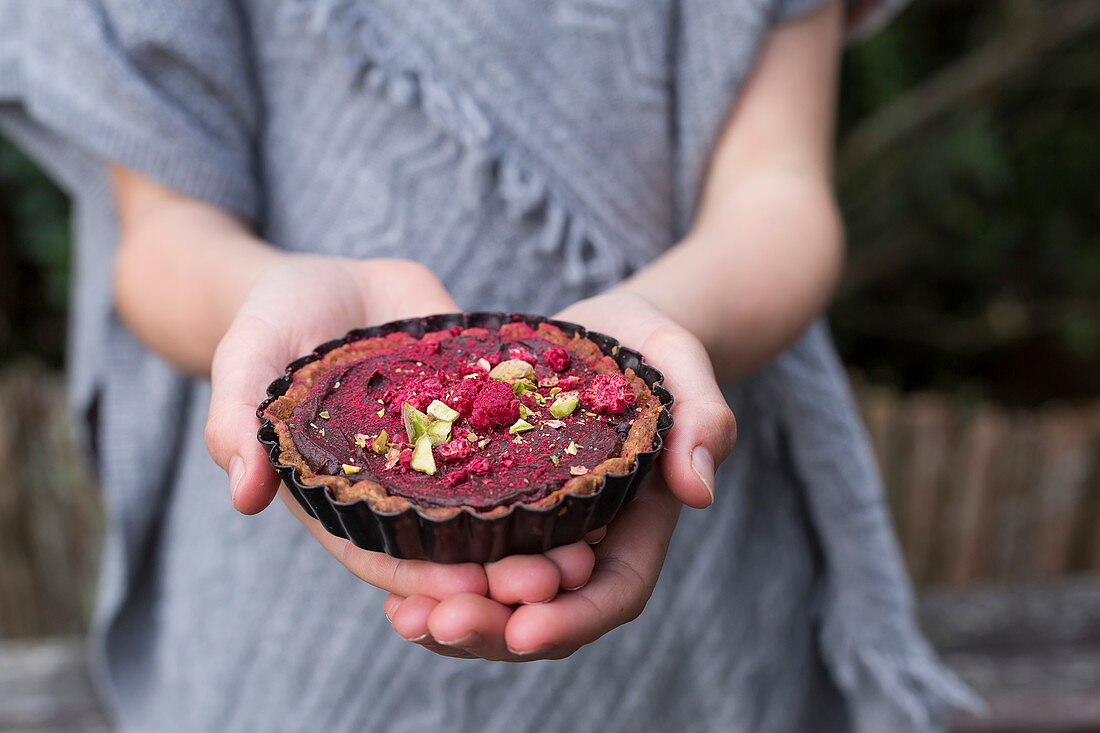 Spiced Chocolate Tarts being held in a girl's hands