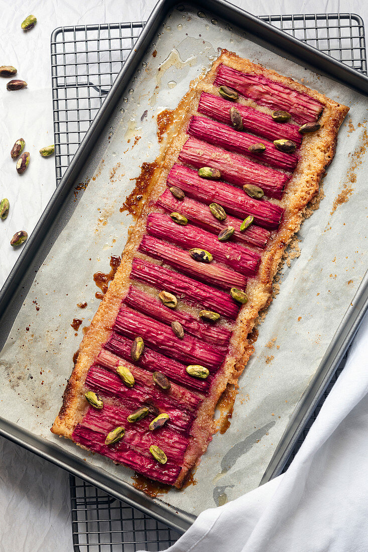 A rhubarb and pistachio nut tart cooling on a baking tray