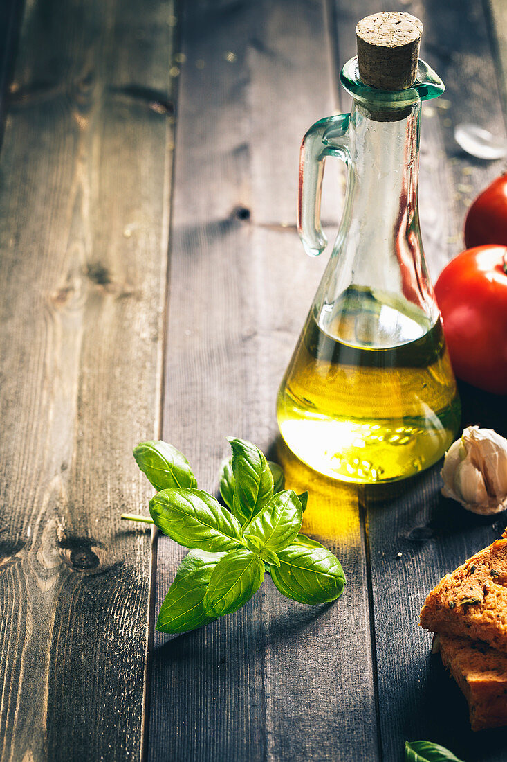 Stillleben mit Olivenöl, Basilikum, Knoblauch, Tomaten und Brot