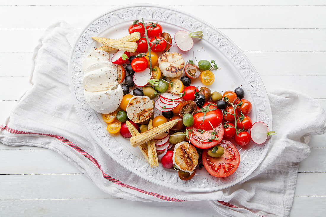 Tomatensalat mit Mozzarella, Knoblauch, Oliven und Maiskölbchen