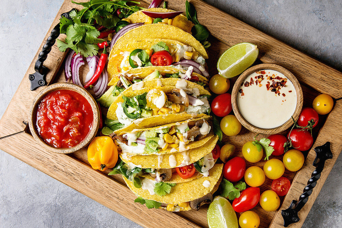Maistacos mit vegetarischer Gemüsefüllung und zweierlei Dips auf Holztablett