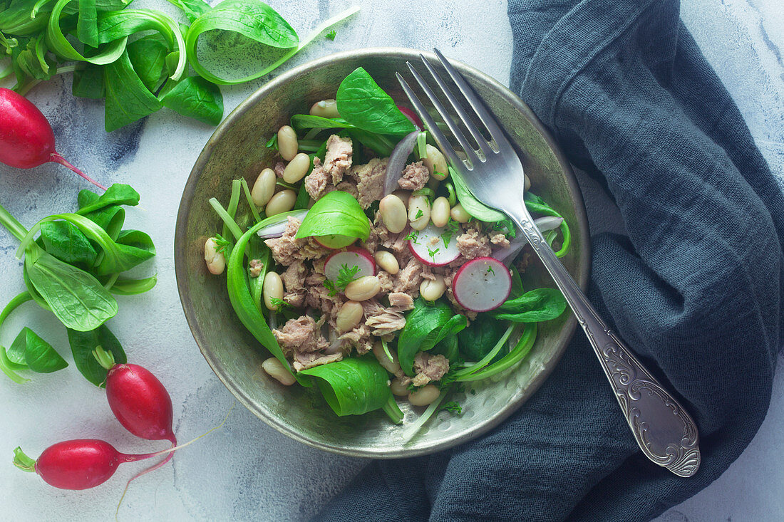 Tuna fish and white bean salad on a metal plate