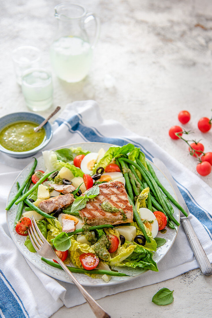 Tuna salad with eggs, olives, tomatoes, beans and Nicoise dressing
