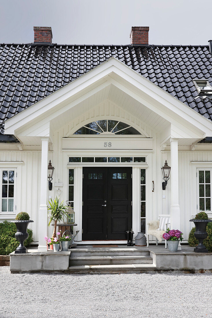 White country house with porch and black roof