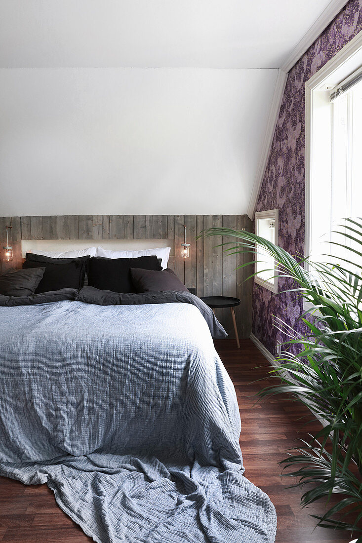 Bedroom with wood-panelled knee wall below sloping ceiling