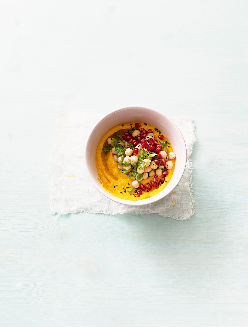 Chickpea salad with pomegranate seeds on carrot cream