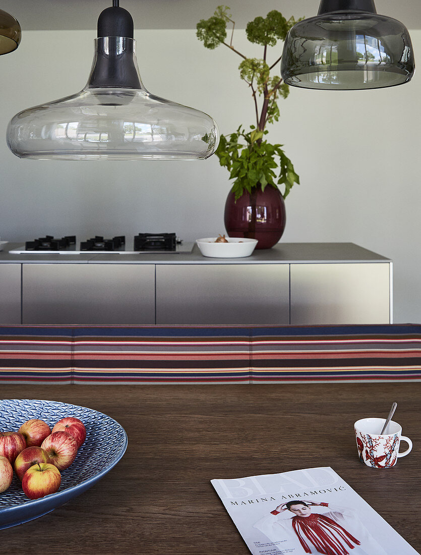 View across dining table to modern kitchen island