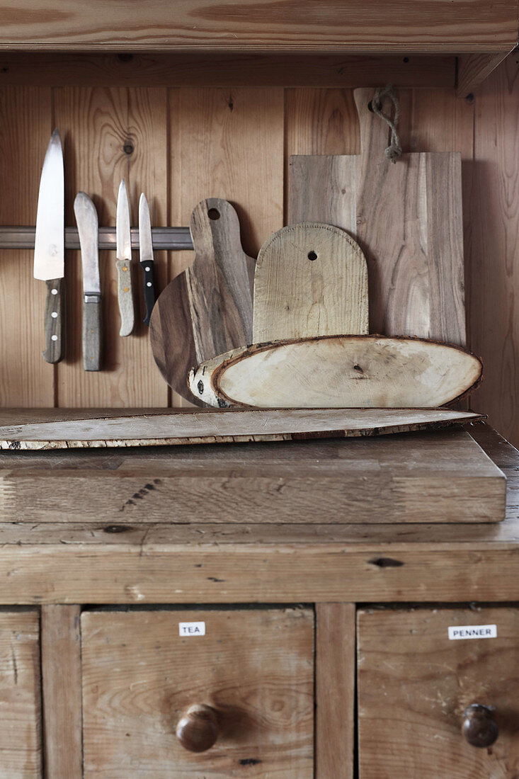 Knives and wooden boards on top of kitchen base cabinet