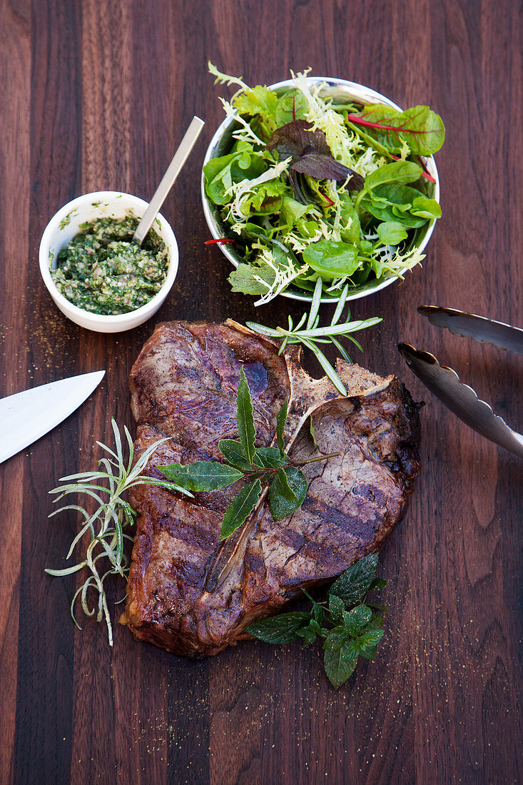 Grilled T-bone steak with salsa verde and a wild herb salad