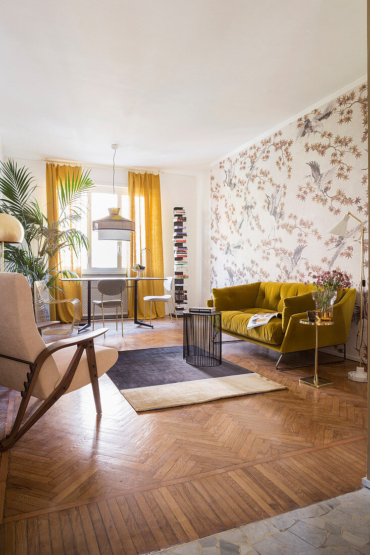 Mustard-yellow sofa and table and chairs below window in living room