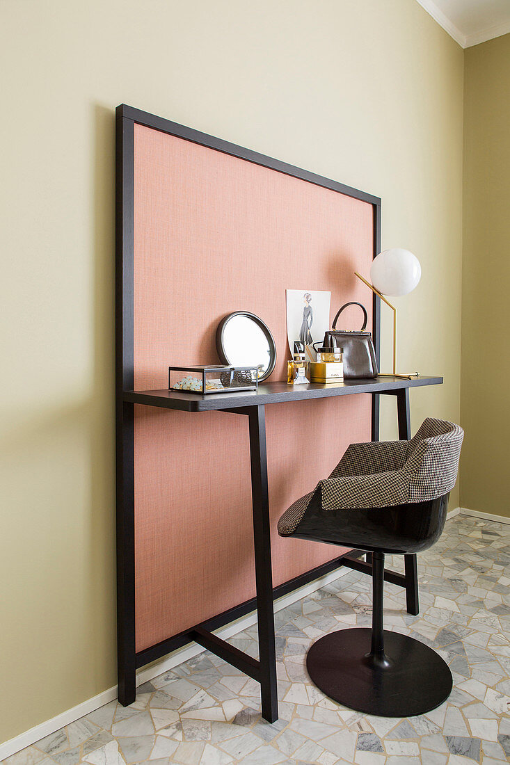 Dressing table against pink panel on green wall in bedroom