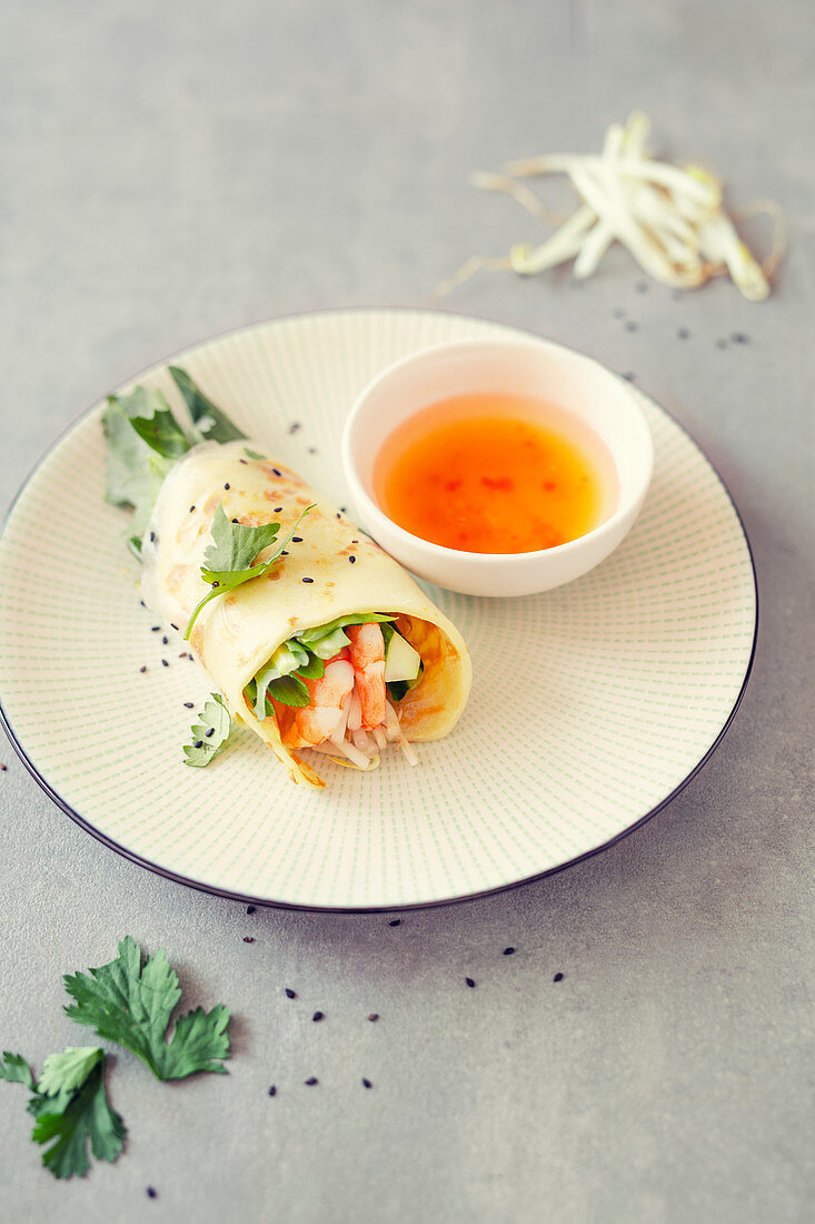 Gefüllter Kokospfannkuchen mit Garnelen und Salat im Reisblatt (Vietnam)