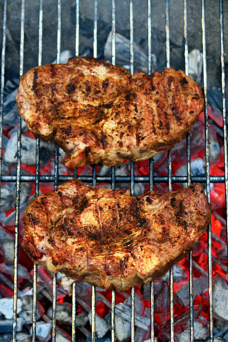 Pork neck steaks on a barbecue