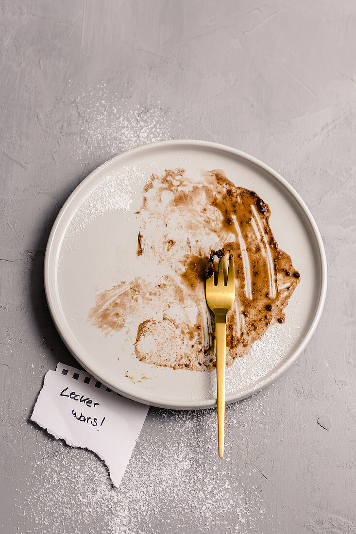 Reste von Schokoladendessert auf Teller mit Gabel