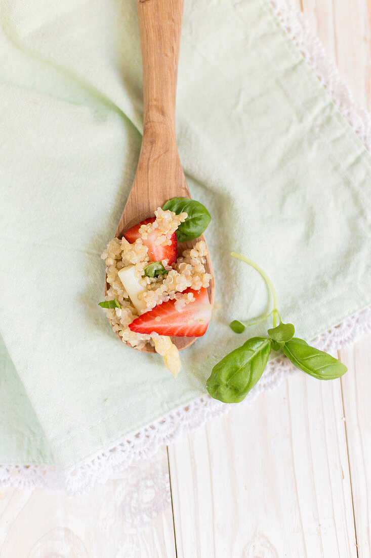 Quinoa with strawberries and rhubarb on a wooden spoon