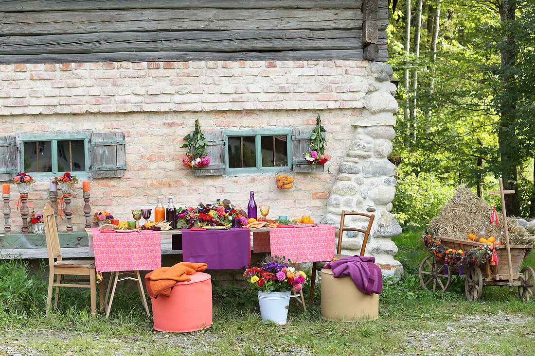 Bunt gedeckter Tisch fürs Erntedankfest vorm Bauernhaus