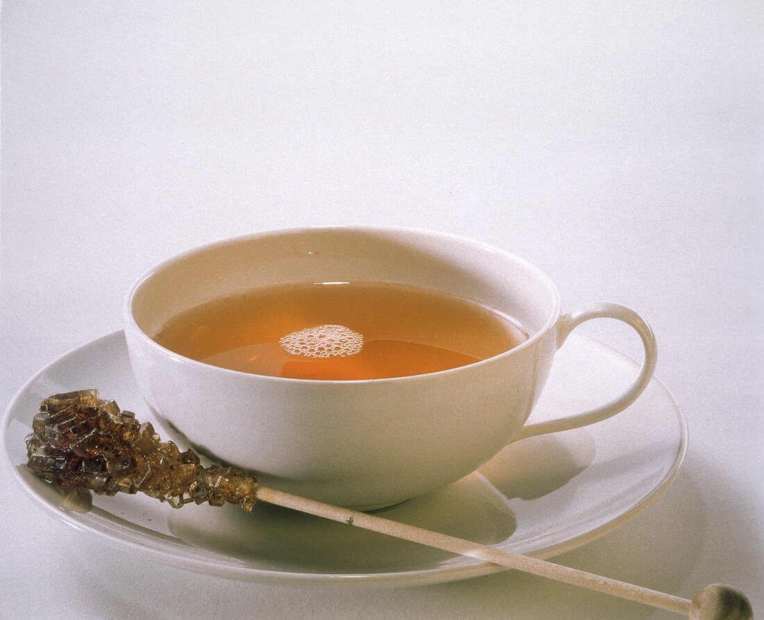 Eine Tasse schwarzer Tee mit Kandisstange