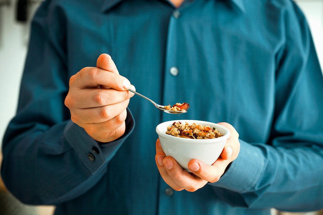 Hands holding a bowl with muesli