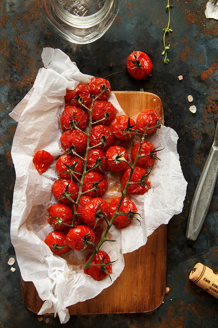 Baked cherry tomatoes on a sheet of baking paper