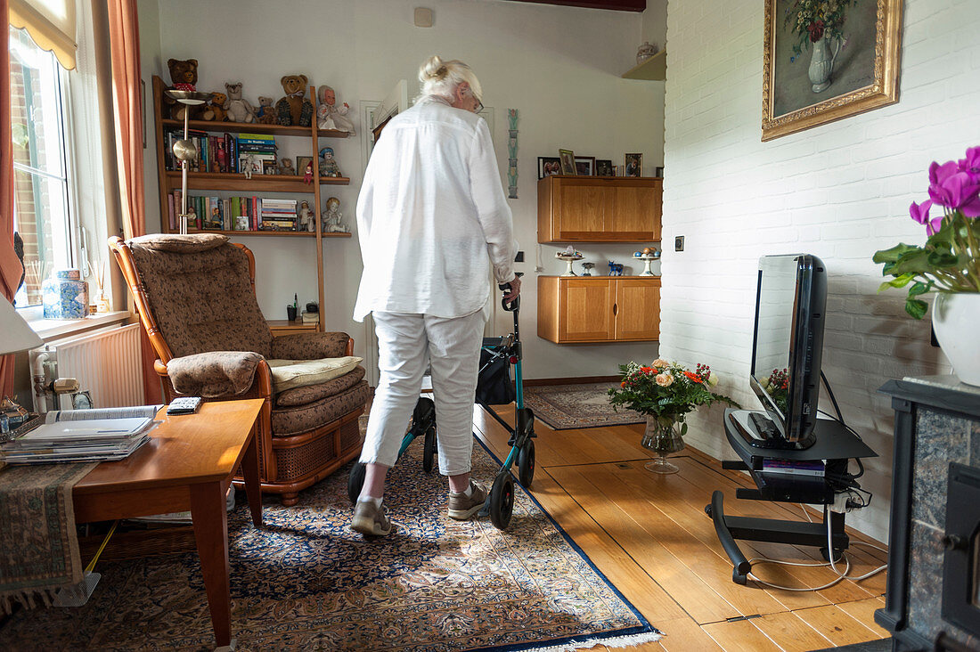 Older woman walking on rug in her home