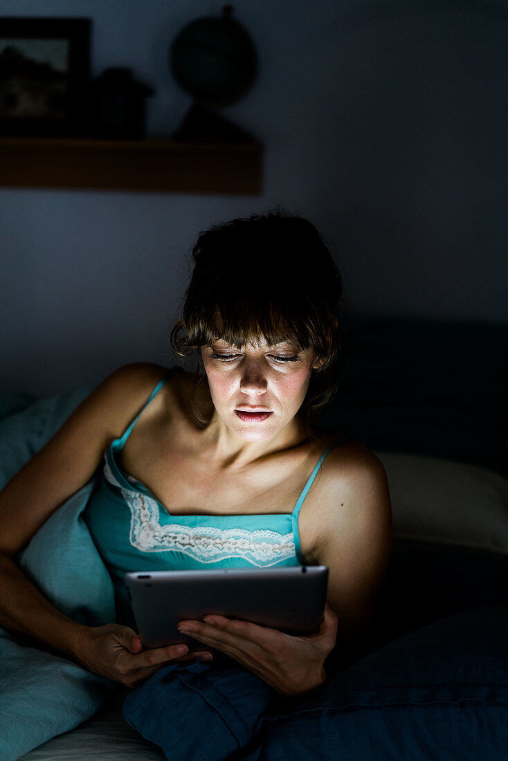 Woman using a digital tablet at night
