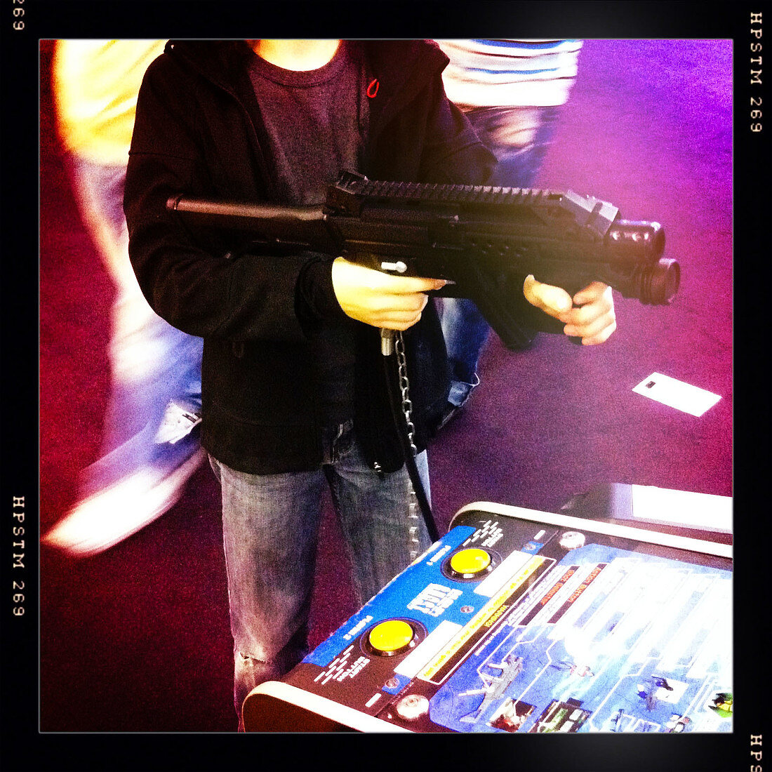 Boy playing at a shooting game in an arcade