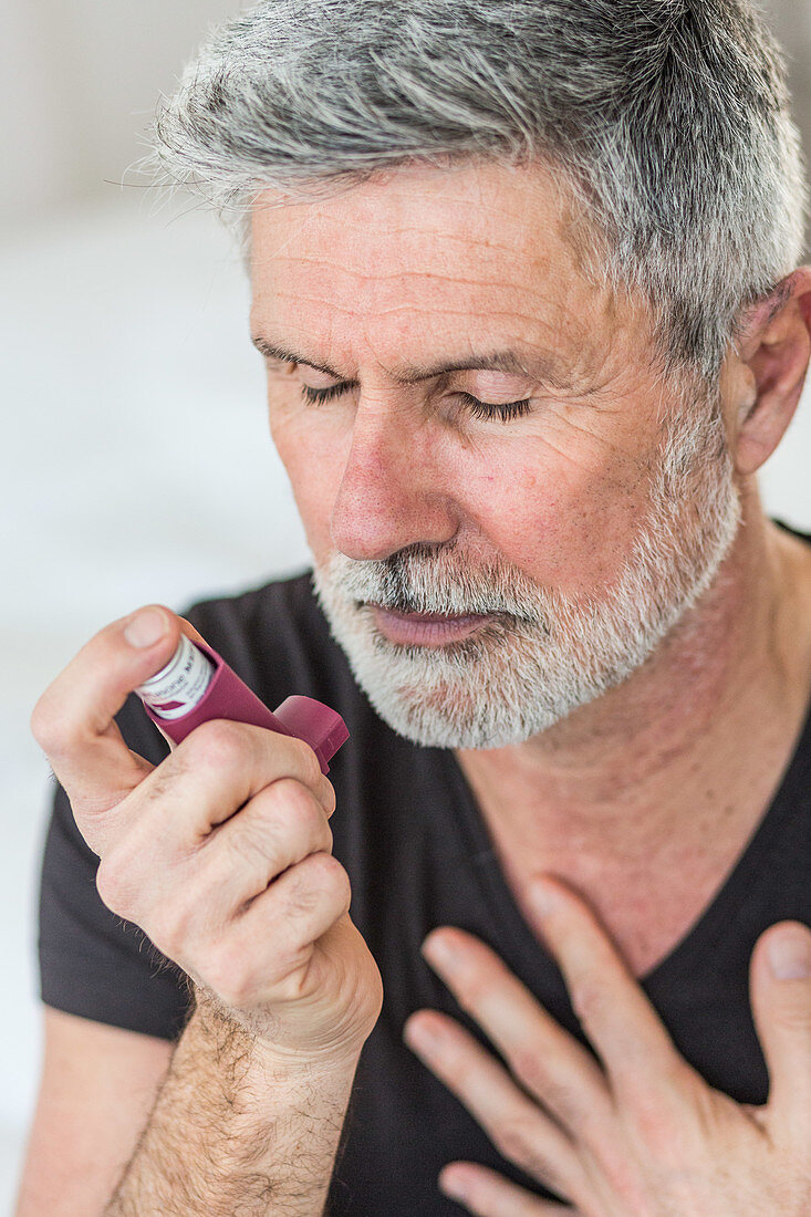 Man using an inhaler during an asthma attack