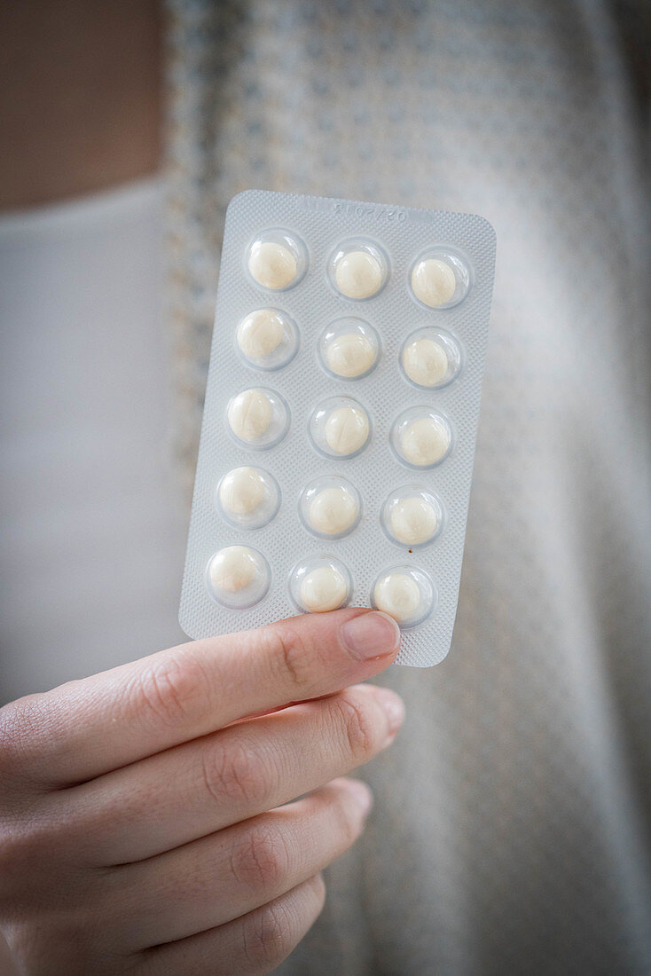 Woman taking an hormone replacement therapy pills