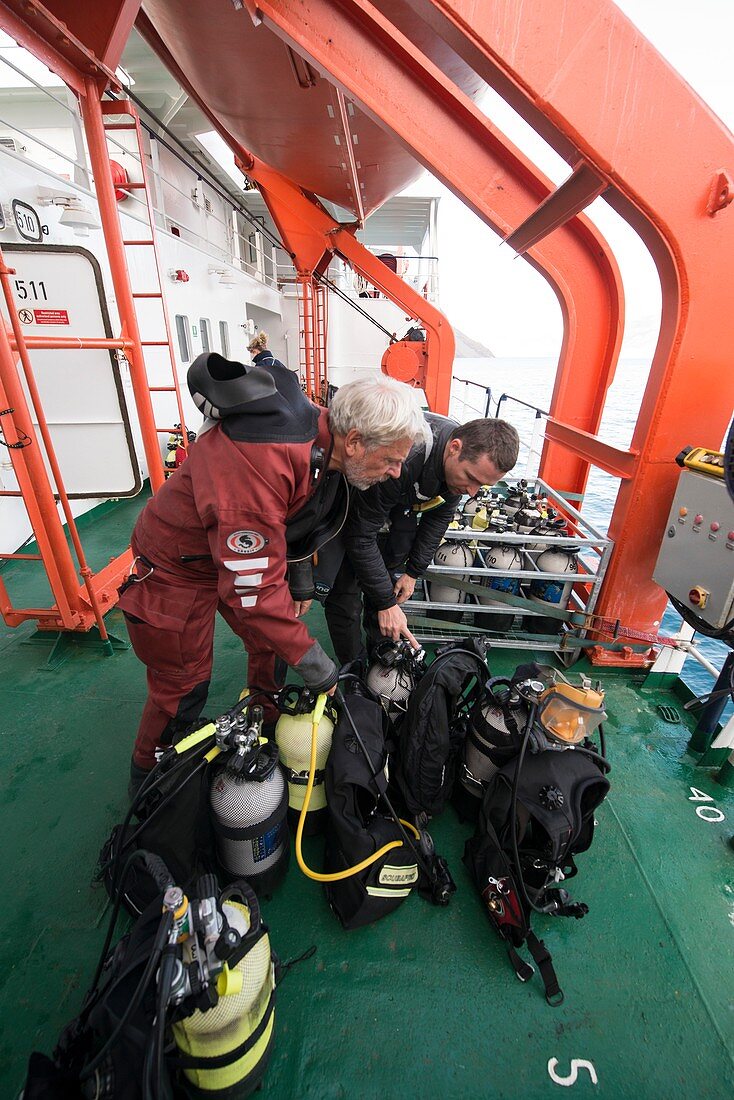 Divers preparing equipment on board ship, Greenland