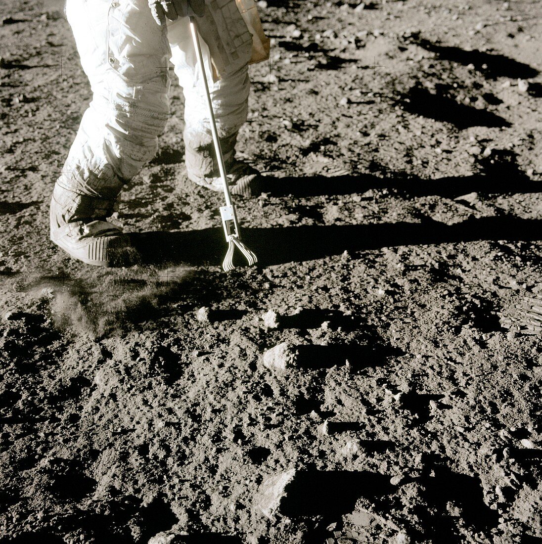 Apollo 12 astronaut using lunar hand tool, 1969
