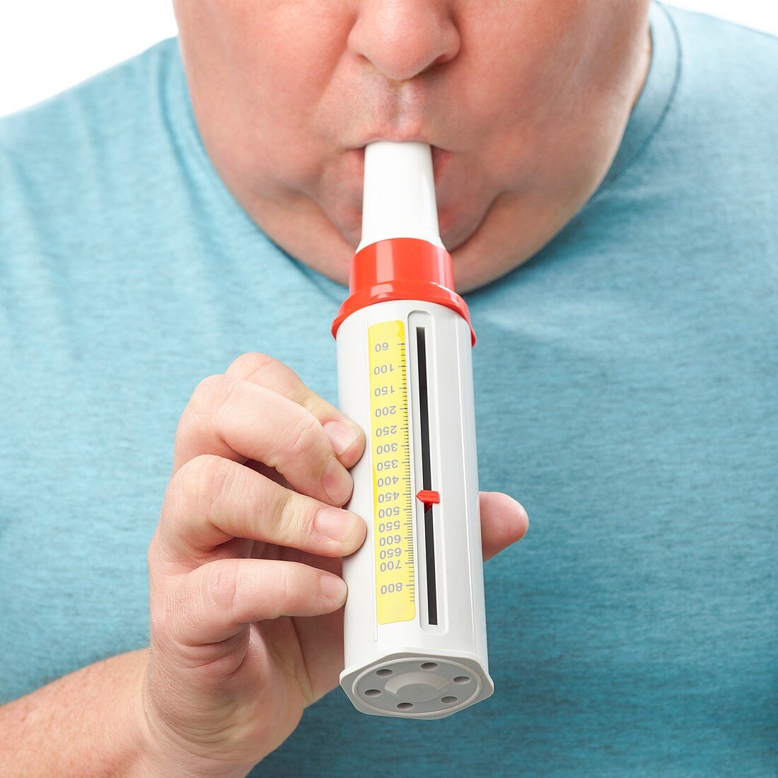 Overweight man using a peak flow metre