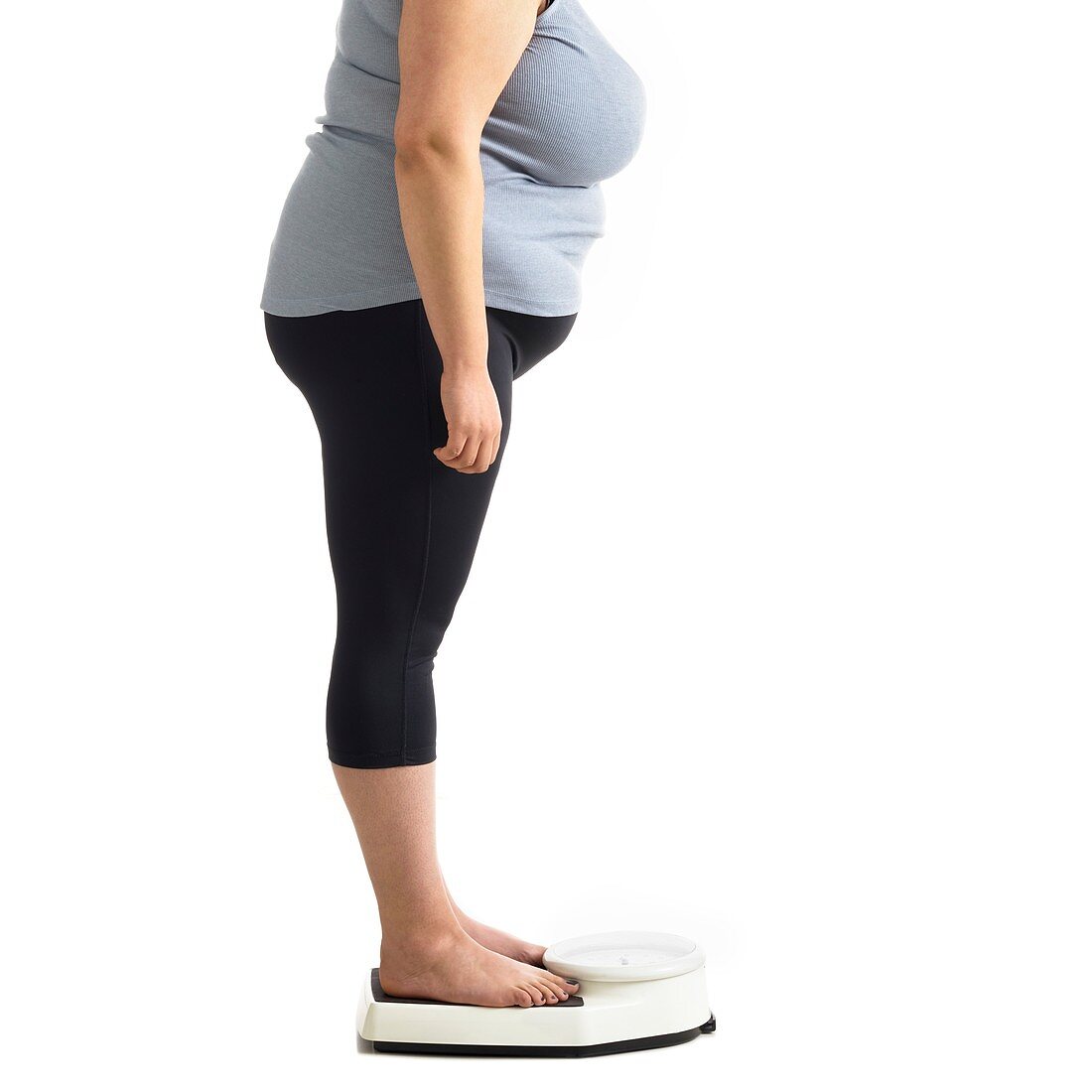 Overweight woman standing on weighing scales