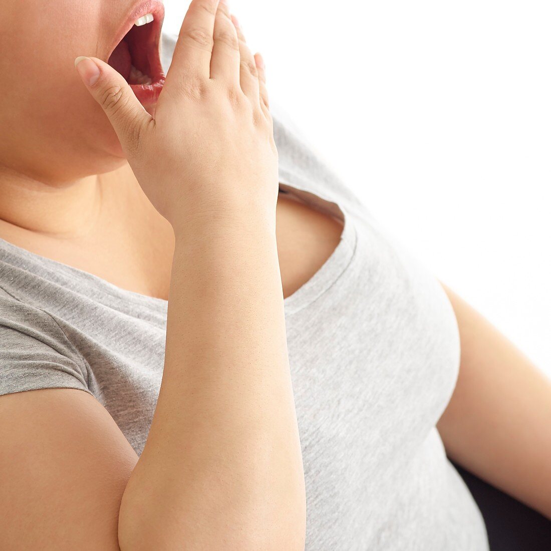 Woman yawning with hand over mouth